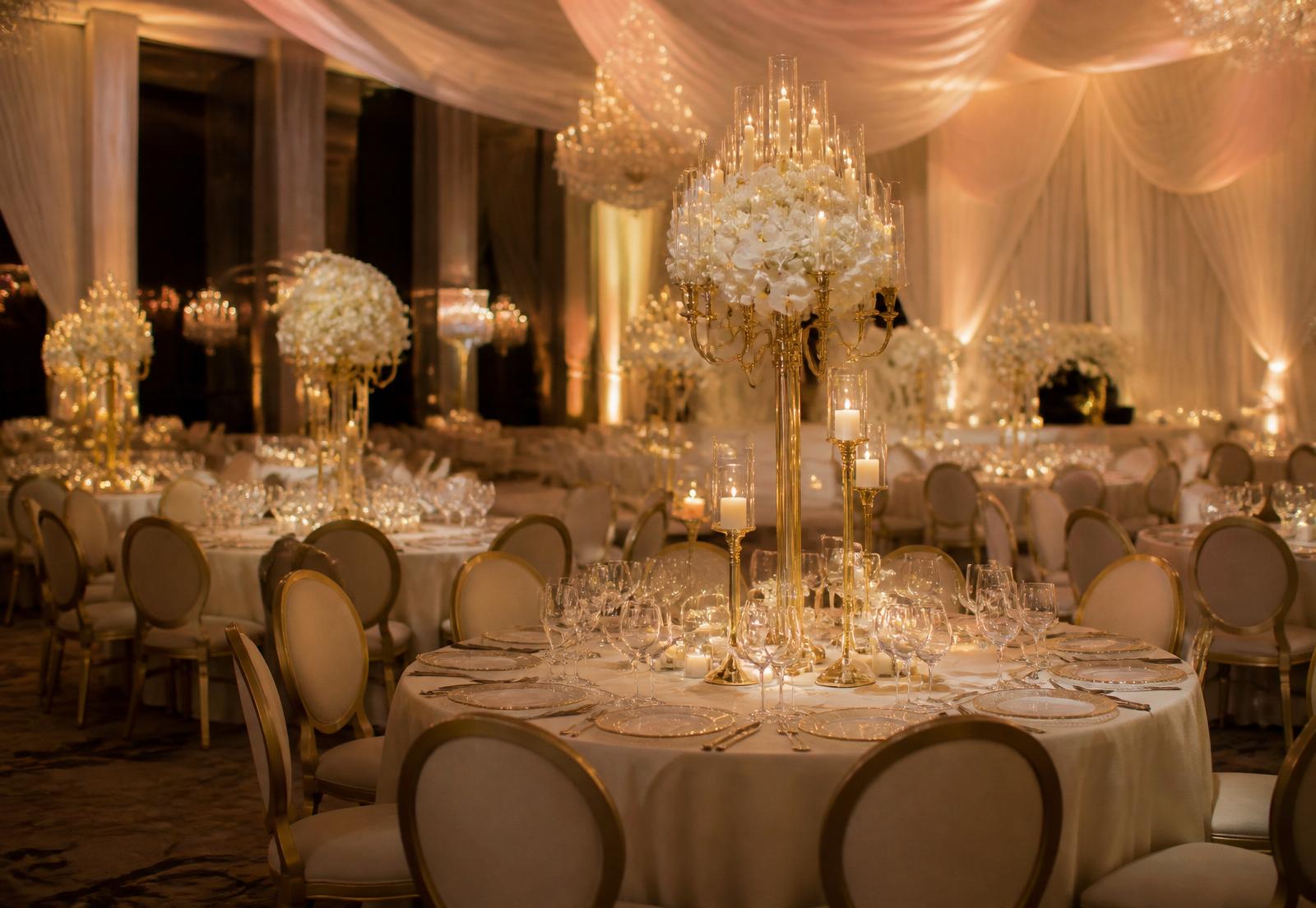 Luxury ballroom reception with candlelit tables and gold accents